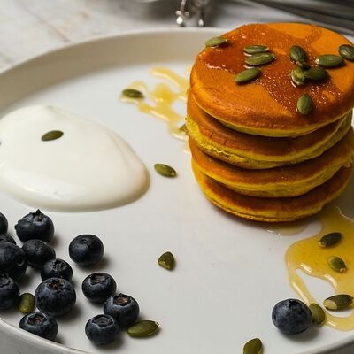 Тыквенные панкейки с медом, сметаной и семечками в Bisou Bisou Bistro по цене 680 ₽