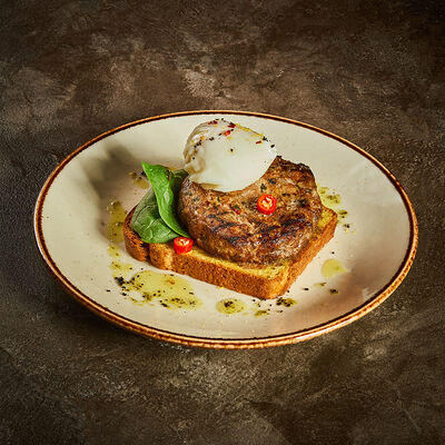 Рубленый бифштекс из говядины на картофельном хлебе с яйцом пашот в Корчма по цене 990 ₽