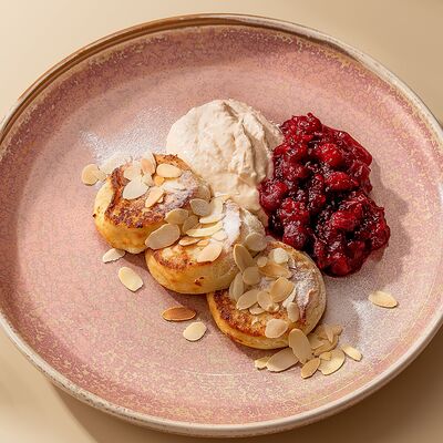 Сырники с кокосовым кремом и вишневым конфи в Комод по цене 455 ₽