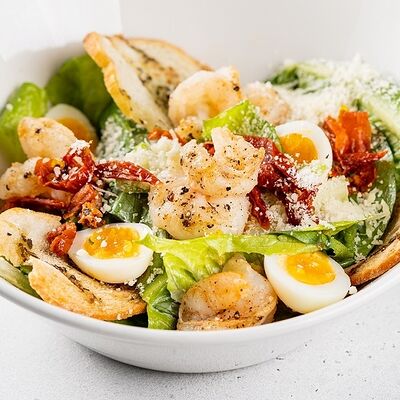 Цезарь с креветками, листьями салата, вялеными томатами, перепелиным яйцом и крутонами в АндерСон по цене 720 ₽