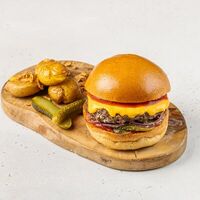 Чизбургер с мраморной говядиной, маринованным огурцом, луком и кетчупом в АндерСон