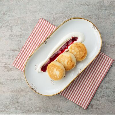 Сырники со сметаной и вишневым вареньем в Или по цене 290 ₽