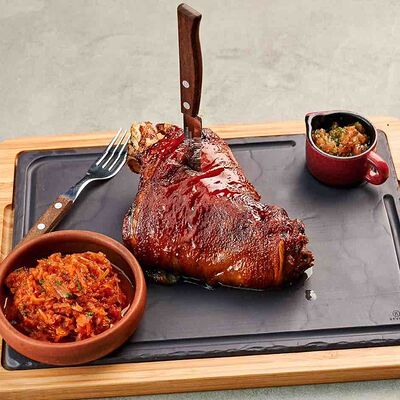 Свиная рулька, запеченная в медовой глазури, с пряной тушеной капустой и соусом сальса в Pivino по цене 990