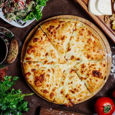 Осетинский пирог с курицей, сыром, грибами и жареным луком в Осетинские пироги Баркад по цене 999 ₽