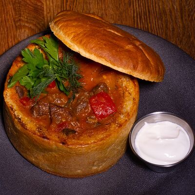 Суп-гуляш в хлебе в Кнедлик по цене 580 ₽