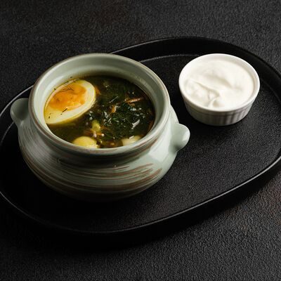 Зеленый борщ с говяжьими фрикадельками, яйцом и сметаной в Де'рибас по цене 715 ₽