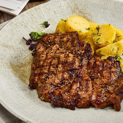 Стейк из свиной шеи с отварным картофелем в Честертон по цене 820 ₽