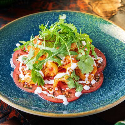 Жареные креветки с чесноком и томатами в Хантама по цене 890 ₽