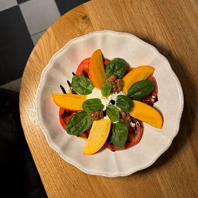 Салат с хурмой, томатами, страчателлой, шпинатом, соусом бальзамик в Фабрика по цене 620 ₽