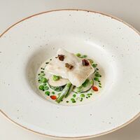 Треска с белым соусом и зеленым горошком в Buana cafe