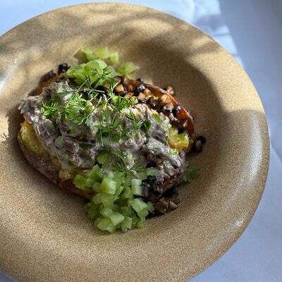 Томленая говядина с грибами в подкопченном соусе на запеченном картофеле в Птичка по цене 760 ₽