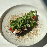 Печеный баклажан с томатами, кинзой и страчателлой в Prana