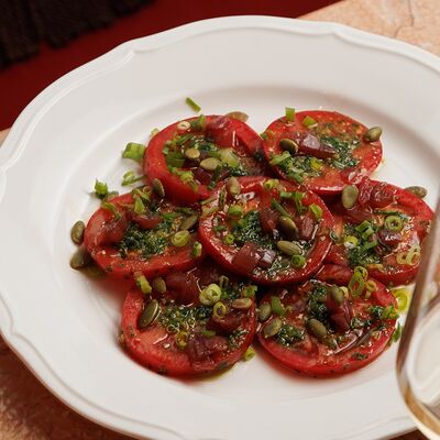 Салат со спелыми томатами, зелёным маслом и тыквенными семечками в TiAMA по цене 650 ₽