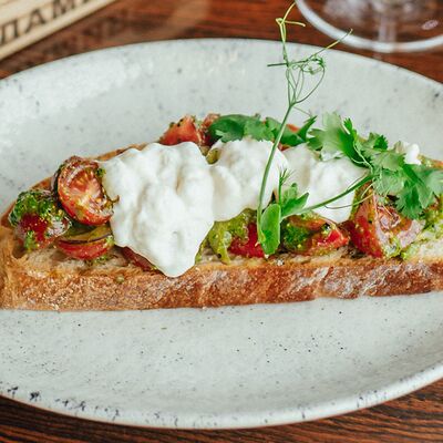 Брускетта с томатами, крымским луком и страчателлой в Макадамия по цене 490 ₽