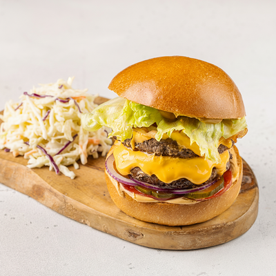 Бургер с двойной котлетой, жареным беконом, маринованным огурцом, красным луком и томатами в АндерСон по цене 1010 ₽