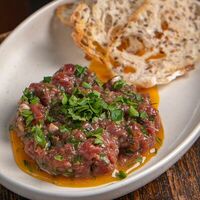 Тартар из говяжьей вырезки с копченым желтком и гренками из зернового хлеба в Masters & Margaritas