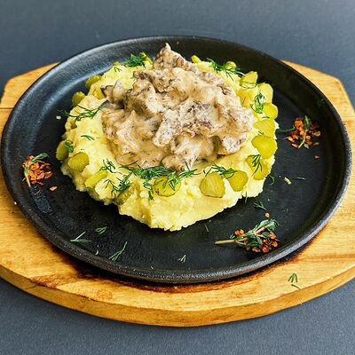 Бефстроганов из говядины с грибами, картофельным пюре и маринованными огурчиками в Трюфель по цене 850 ₽