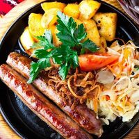 Колбаски свиные с картофелем по-деревенски и тушеной капустой в Брюссель