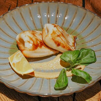 Кальмары на гриле, обжаренные в дровяной печи, с соусом айоли и лимоном в Rekki Pizza & Cocktail Bar по цене 890 ₽