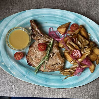 Стейк из свинины на косточке с картофелем в Сиртаки по цене 680 ₽