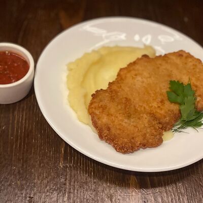 Куриный шницель с картофельным пюре и томатным соусом в Евгенич по цене 550 ₽