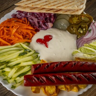 Хот-дог на тарелке в Вкусная и сочная по цене 409 ₽