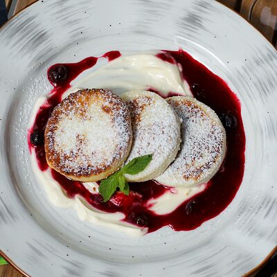 Сырники с ягодным соусом и сметаной в Чебуреки решают! по цене 348 ₽