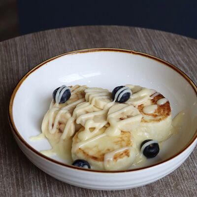 Сырники с заварным кремом, бананом и сезонными ягодами в Локация кофе по цене 440 ₽