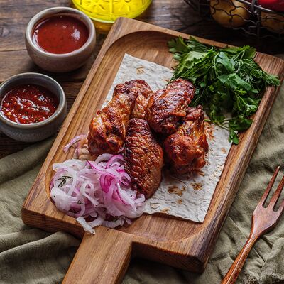 Куриные крылья на мангале в Пельмения по цене 684 ₽