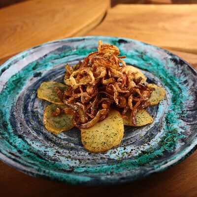 Свиные уши на картофельных слайсах с луковыми чипсами в Рога Лося по цене 320 ₽