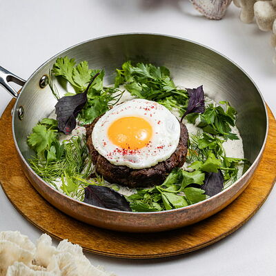 Бифштекс рубленым с сыром чеддер, яйцом и соусом из зеленого горошка в More & More по цене 1450 ₽