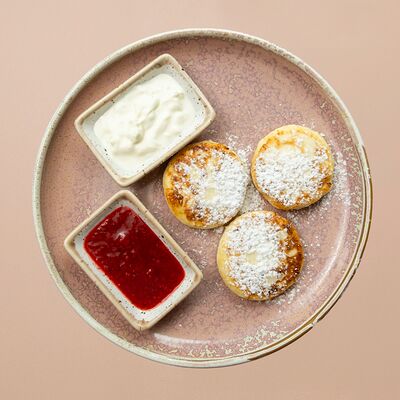 Сырники с малиновым соусом и сметаной в Романовская пекарня по цене 600 ₽