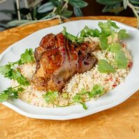 Томленая баранья голень с кускусом в Grecco