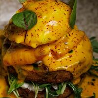 Зеленые оладьи из кабачка с лососем, яйцом пашот и голландским соусом в Ресторан Строгов