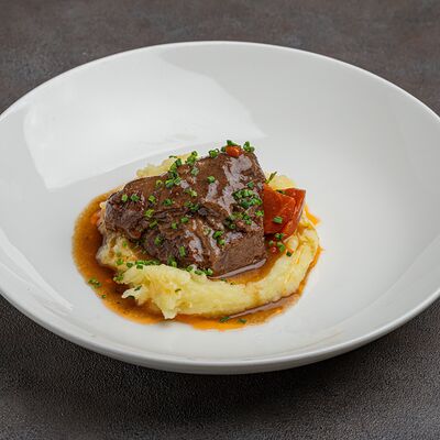 Томленые говяжьи щеки с картофельным пюрев МОСТ бистро по цене 950 ₽