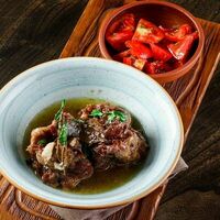 Бычий хвост с салатом из рубленых помидоров, чеснока и петрушки в Па-Паэлья