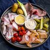 Мясная тарелка с соленьями и молодым картофелем в Бык и море по цене 890