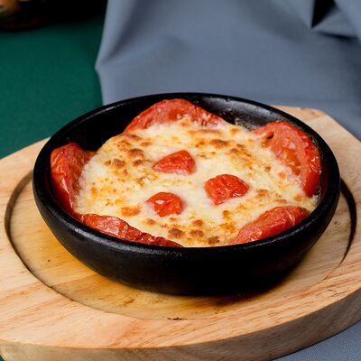 Запечённый сыр сулугуни с помидорами в Пиросмани по цене 580 ₽