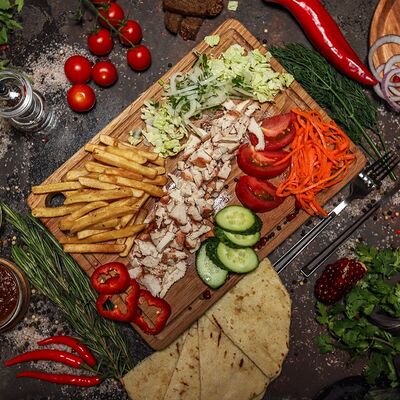 Гирос с курицей на тарелке в Шашлычная бостан по цене 699 ₽