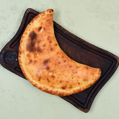 Кальцоне с ветчиной и грибами в Пармезан и пури по цене 335 ₽