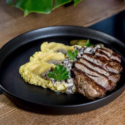 Стейк из cвинoй шеи с грибным соусом и картофельным пюре в Гриль-бар Бикью по цене 840 ₽