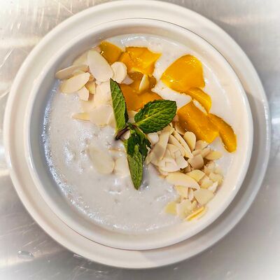 Рисовая каша на кокосовом молоке с манго и лепестками миндаля в Панеттоле по цене 345 ₽