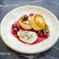 Фирменные сырники с вишневым соусом и сметаной в The Brasserie