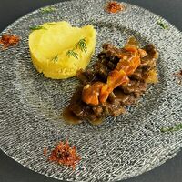 Томленые телячьи щечки с мясным соусом и картофельным пюре в Трюфель