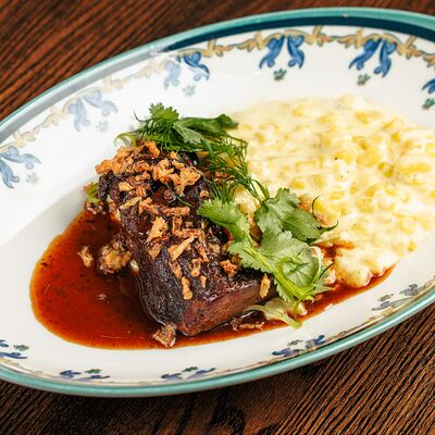 Щёчки говяжьи с картофельной кашей и луком фри в Паб старый чемодан по цене 1200 ₽