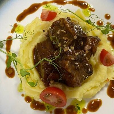 Томленые телячьи щечки в цитрусовом соке на подушке из картофельного пюре в ОстроVok по цене 950 ₽