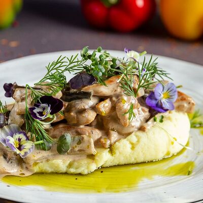 Томленое филе цыпленка с овощами и зеленью на подушке из воздушного пюре в Koyroi по цене 440 ₽