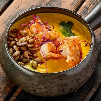 Тыквенный крем-суп на кокосовом молоке с креветками и попкорном из тыквенных семечекв Про печь по цене 665 ₽