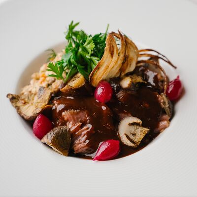 Томлёная говяжья щека с белыми грибами, кремом из печёного лука-порея и зелёной гречкой в Круча по цене 1450 ₽