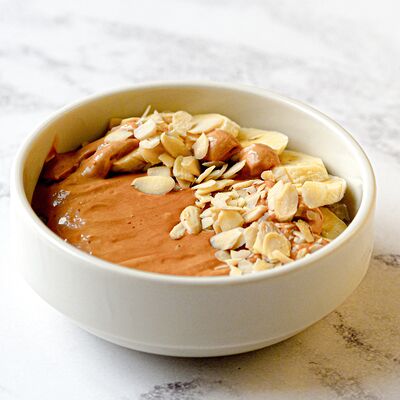 Овсяная каша с бананом, соусом из вареной сгущенки и миндалем в Stories по цене 300 ₽